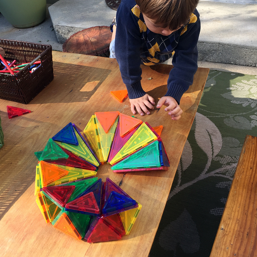 Building with Magna Tiles in the Yard